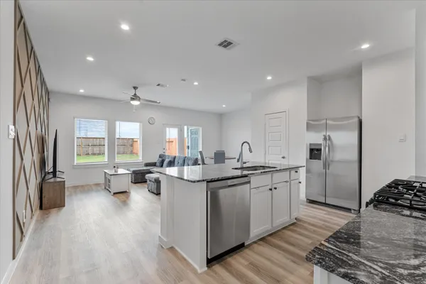 a kitchen with sink stove and refrigerator