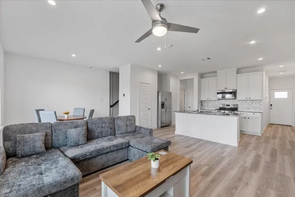 a living room with furniture kitchen and a chandelier