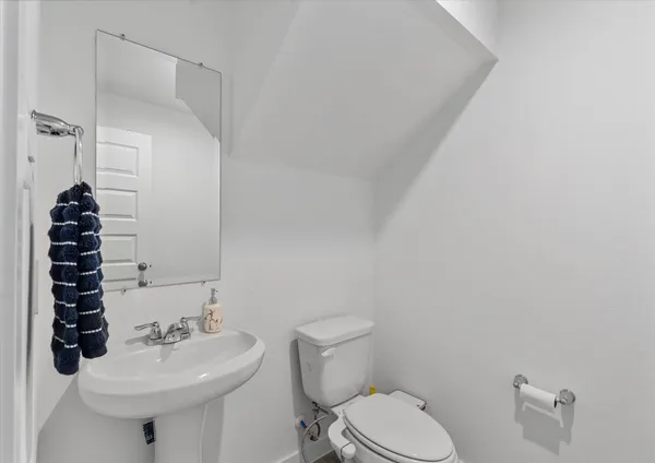 a bathroom with a sink toilet and a mirror