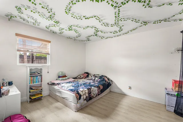 a bedroom with a bed chandelier and a window