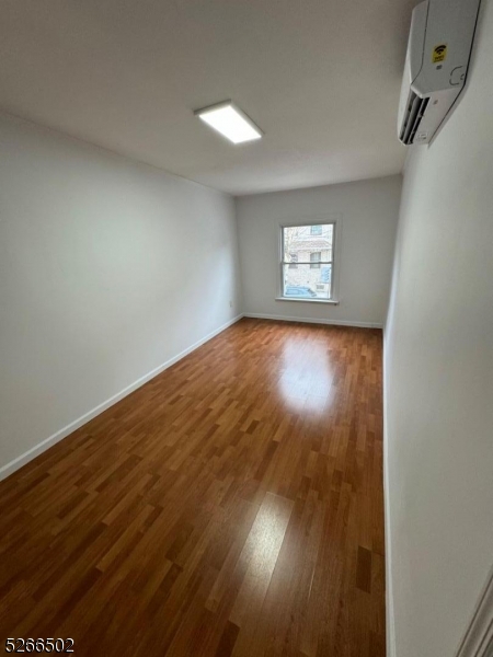 158 Lafayette Street, Unit 2 Newark, NJ 07105 - Photo 12 of 16 an empty room with wooden floor and windows