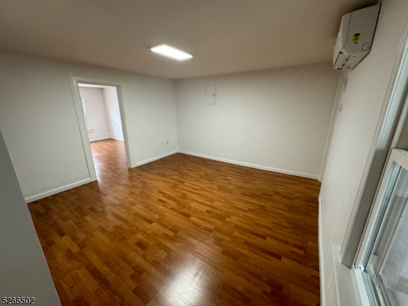 158 Lafayette Street, Unit 2 Newark, NJ 07105 - Photo 14 of 16 a view of an empty room with wooden floor and a window