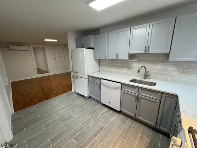 a kitchen with a sink a refrigerator and cabinets