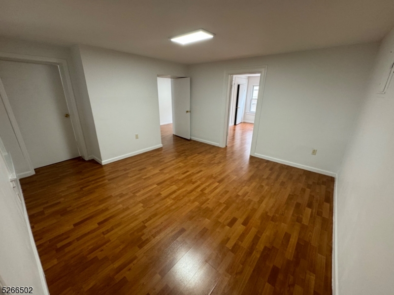 158 Lafayette Street, Unit 2 Newark, NJ 07105 - Photo 9 of 16 an empty room with wooden floor and windows
