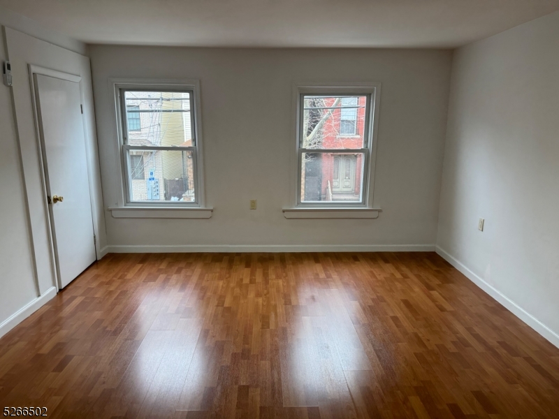 158 Lafayette Street, Unit 2 Newark, NJ 07105 - Photo 10 of 16 an empty room with wooden floor and windows