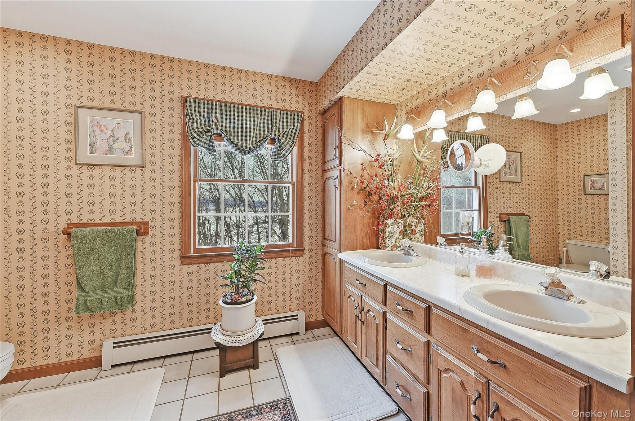 183 High Meadows Road Walden, NY 12586 - Photo 33 of 44 Full bathroom featuring double vanity, wallpapered walls, light tile patterned floors, and a baseboard radiator