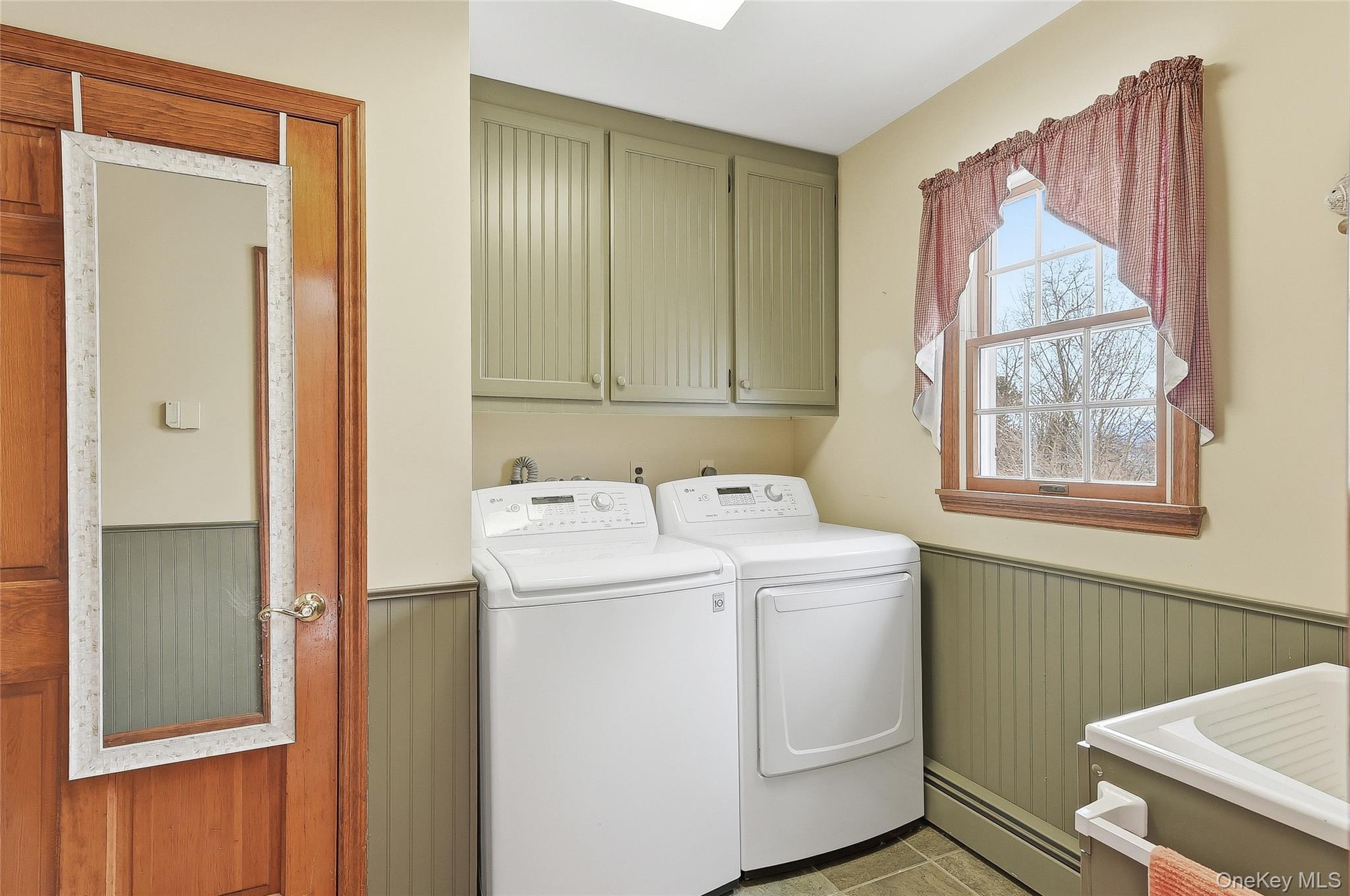 183 High Meadows Road Walden, NY 12586 - Photo 39 of 44 Laundry area with a wainscoted wall, a baseboard radiator, cabinet space, washing machine and dryer, and a skylight