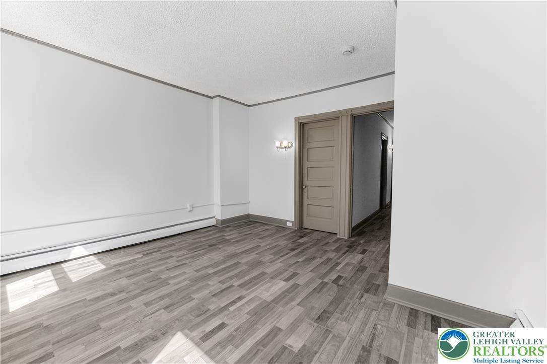 1128 Maple Street Bethlehem, PA 18018 - Photo 13 of 34 Natural light illuminates the durable wood-look flooring in this adaptable living space.