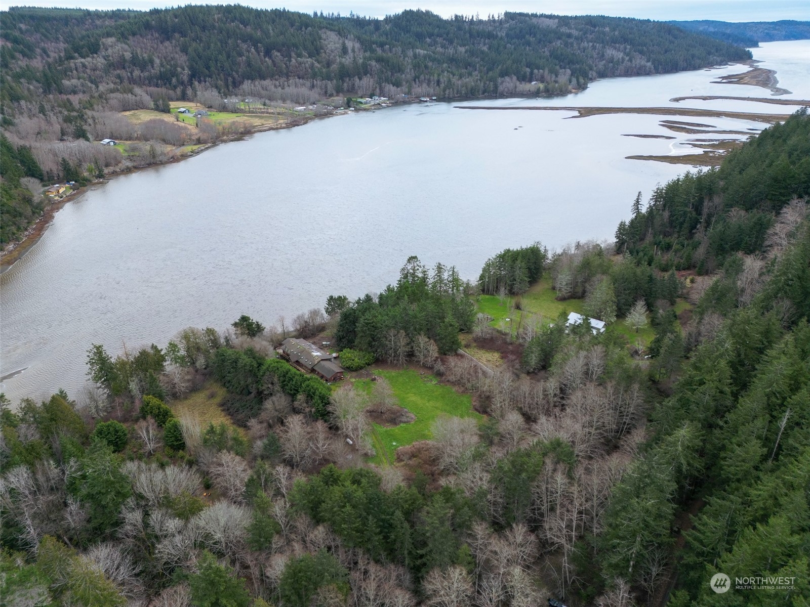 981 Carl Johnson Road Quilcene, WA 98376 - Photo 2 of 15 a view of a lake in middle of the field and trees