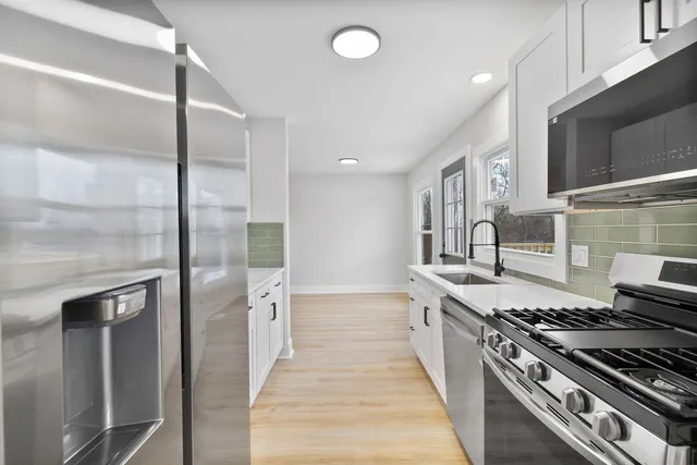 a large kitchen with stainless steel appliances granite countertop a stove and a refrigerator