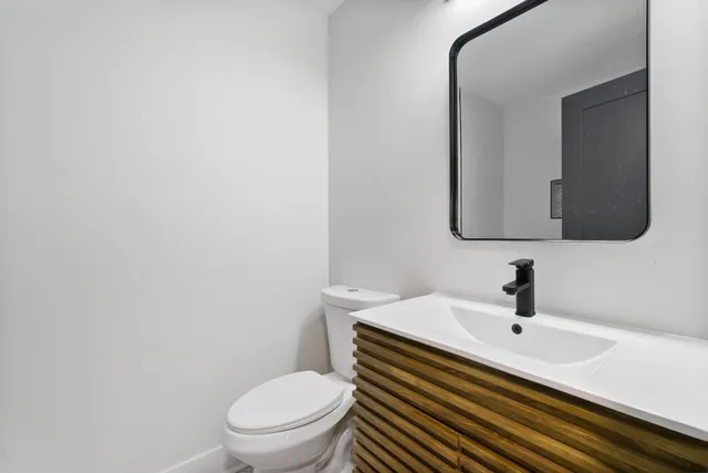 a bathroom with a sink a toilet and mirror