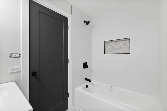 a white bath tub sitting next to a white sink