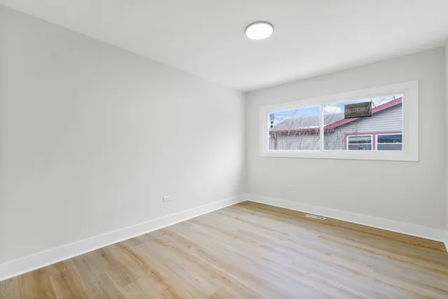 a view of a room with wooden floor and window