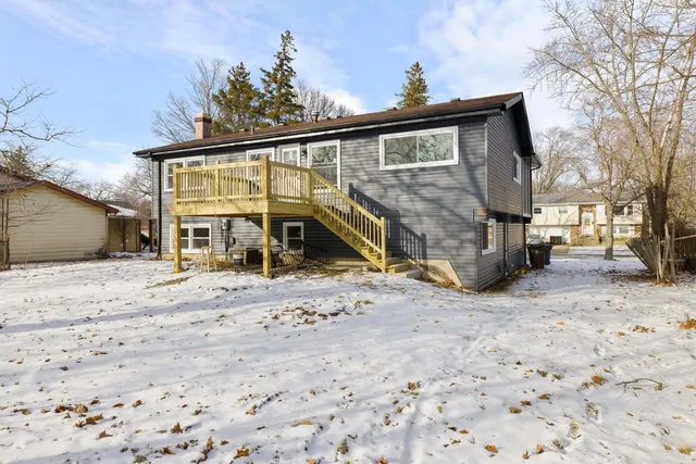 a front view of a house with a yard covered with snow in front of house