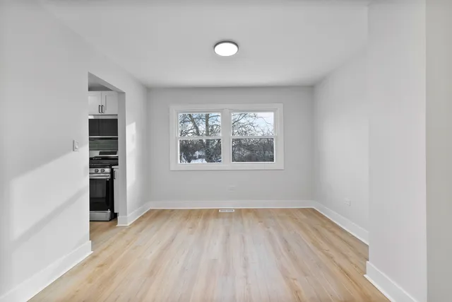 an empty room with window and wooden floor