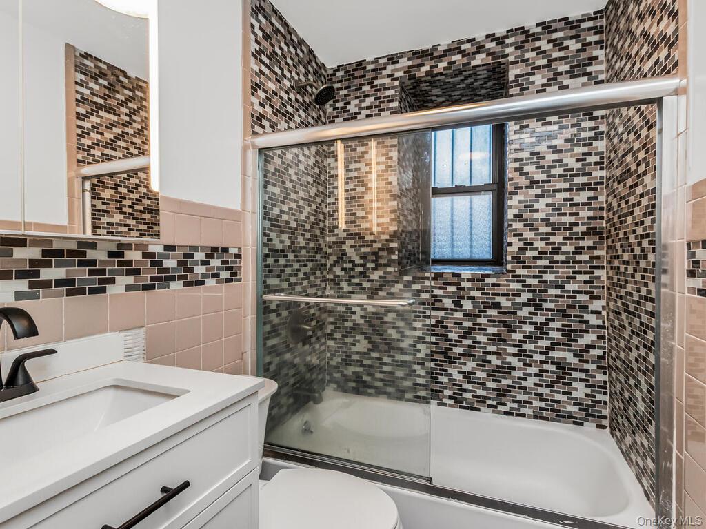 581 Academy Street, Unit GLE Manhattan, NY 10034 - Photo 10 of 18 a bathroom with a sink a toilet and shower