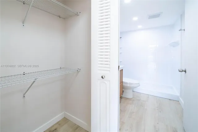 a bathroom view with a shower and a toilet