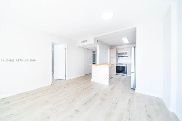 a view of a kitchen with a sink and a refrigerator