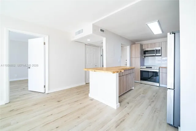 a kitchen with a refrigerator and a stove top oven