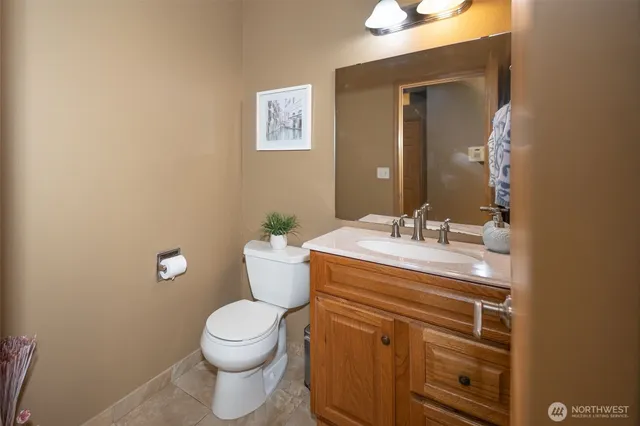 a bathroom with a granite countertop toilet and a sink