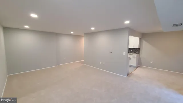 an empty room with an empty space and a kitchen space