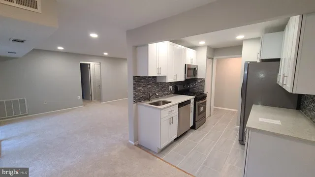 a kitchen with a sink a refrigerator and cabinets