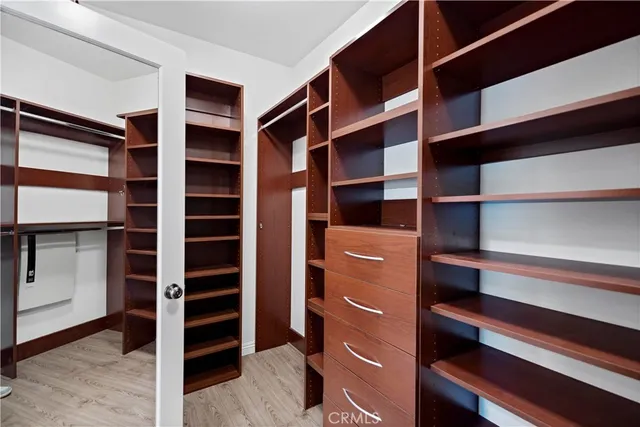 a view of walk in closet with clothes and shoes