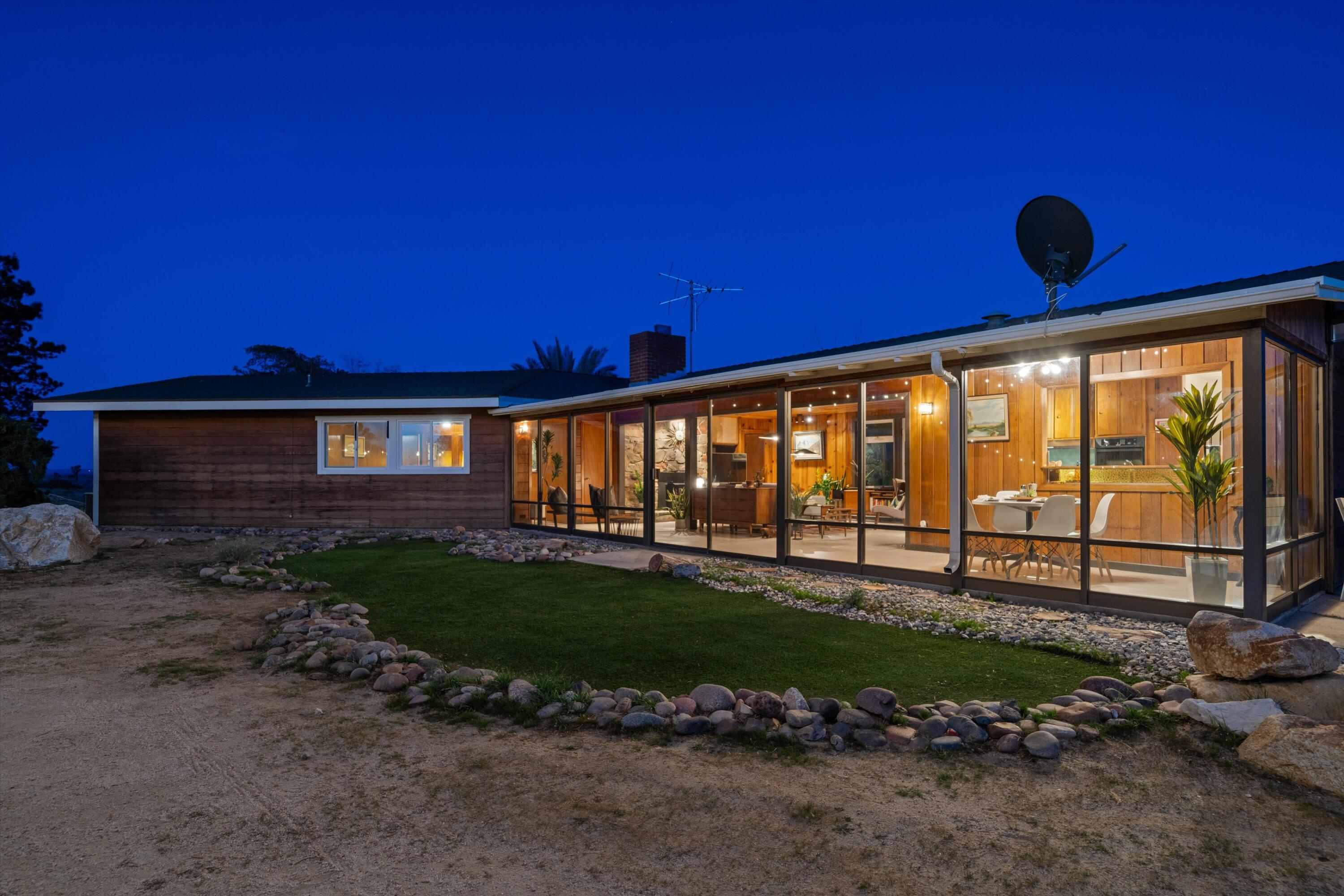 a view of a house with backyard and sitting area