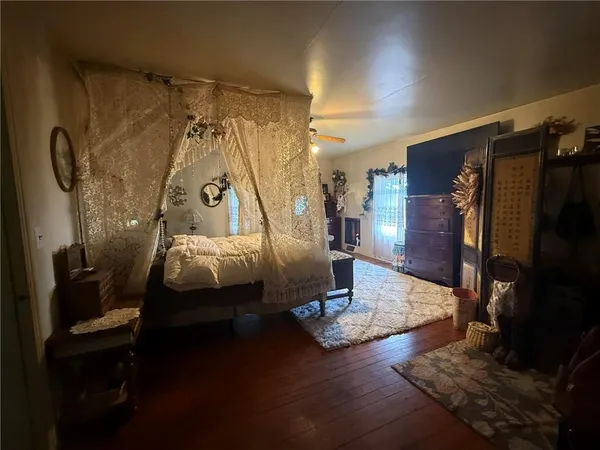 a living room with table chairs and a wooden floor