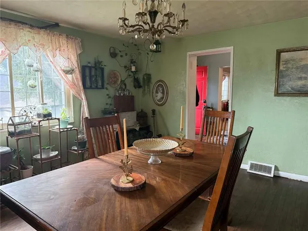 a view of a dining room with furniture a chandelier and wooden floor