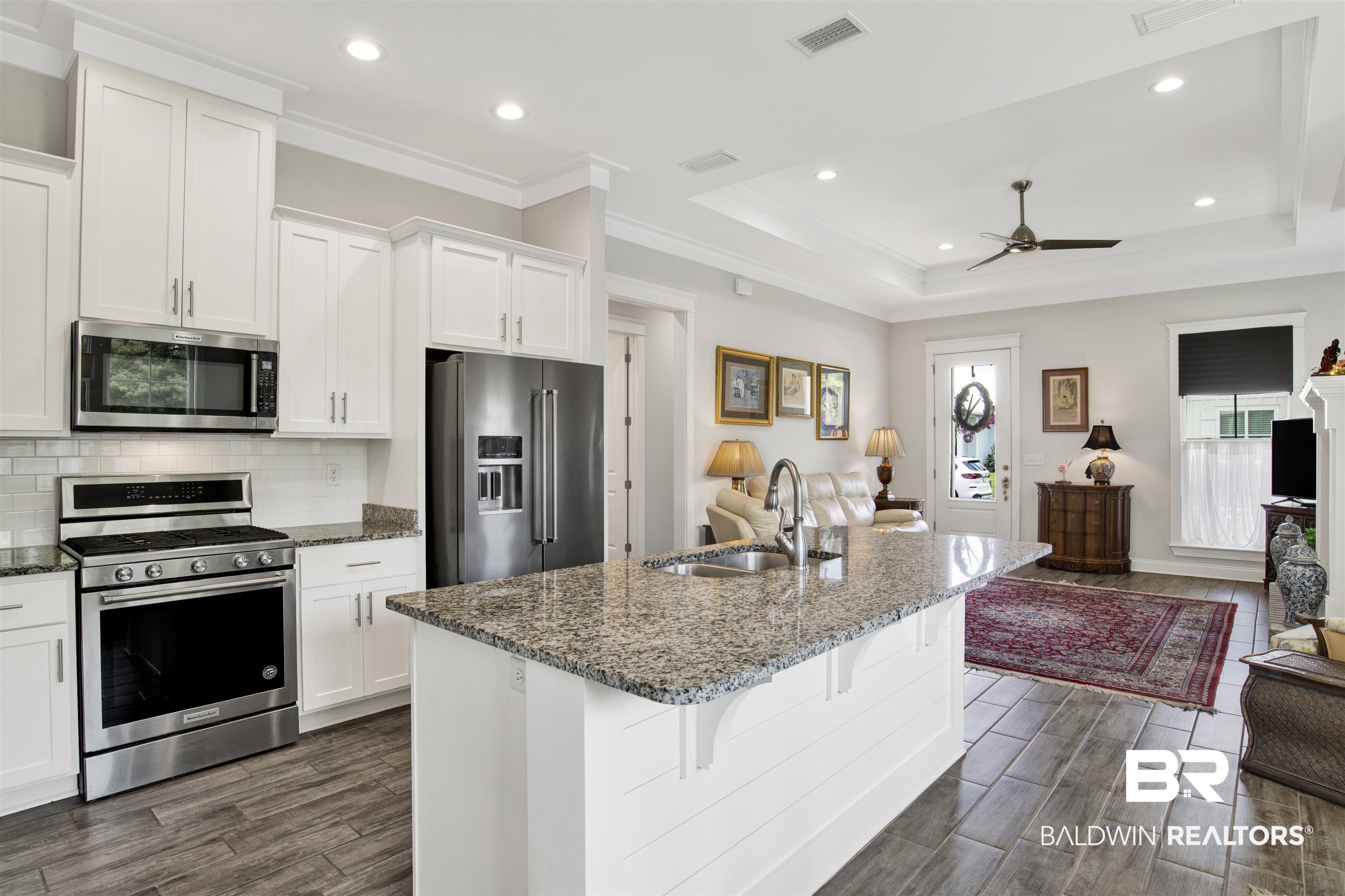 23893 Cypress Crossing Orange Beach, AL 36561 - Photo 22 of 22 Kitchen featuring open floor plan, stainless steel appliances, ceiling fan, dark wood-style floors, and a tray ceiling