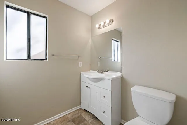 a view of bathroom with a toilet sink and mirror