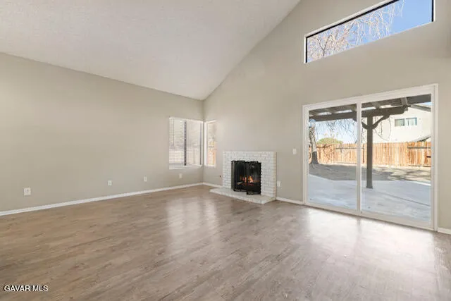 a view of an empty room with a fireplace and a window