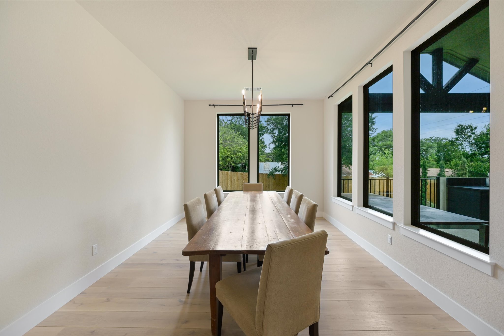 913 Presa Arriba Road Austin, TX 78733 - Photo 9 of 30 Natural light floods this dining room with abundant windows and hardwood flooring.