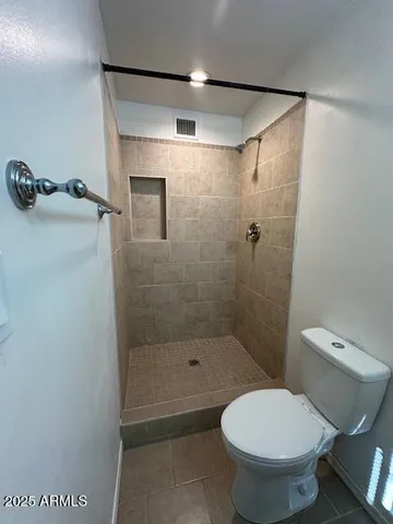 a bathroom with a toilet and a shower