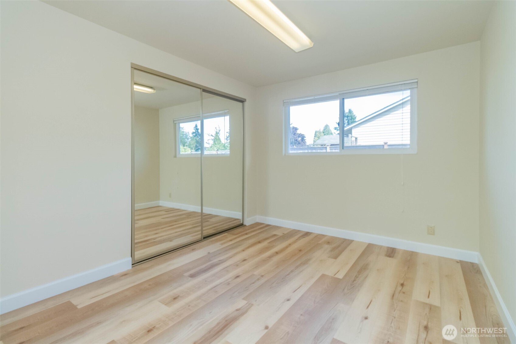 16958 121st Avenue Southeast Renton, WA 98058 - Photo 16 of 34 an empty room with wooden floor and windows