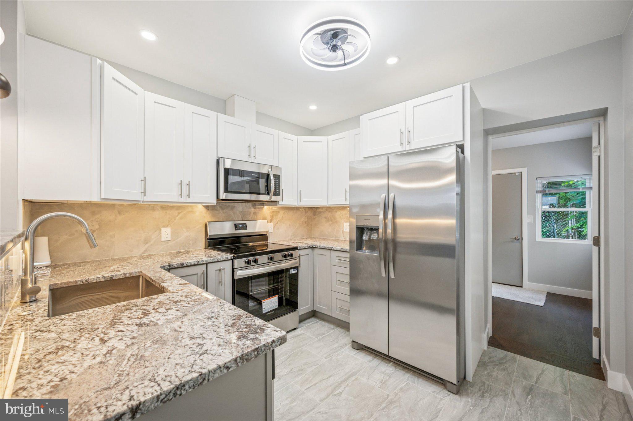 3026 Page Street Philadelphia, PA 19121 - Photo 9 of 24 a kitchen with a refrigerator sink and stainless steel appliances