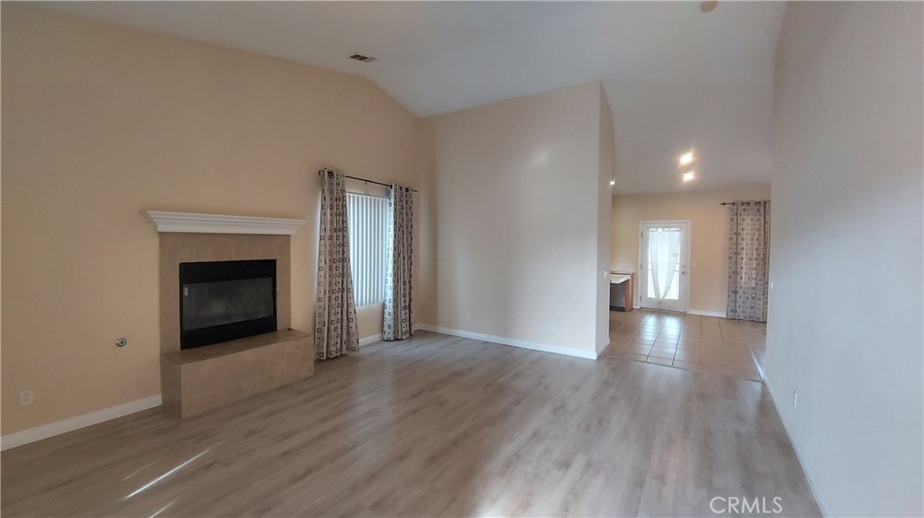 16124 Holly Ridge Court Victorville, CA 92395 - Photo 5 of 24 a view of a livingroom with wooden floor and a fireplace