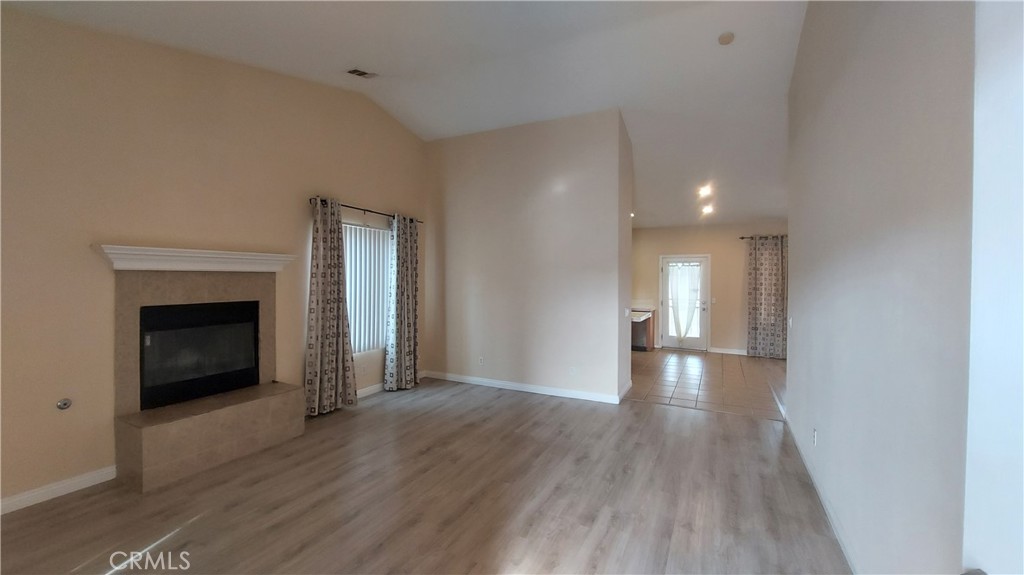 16124 Holly Ridge Court Victorville, CA 92395 - Photo 6 of 24 a view of a livingroom with wooden floor and a fireplace