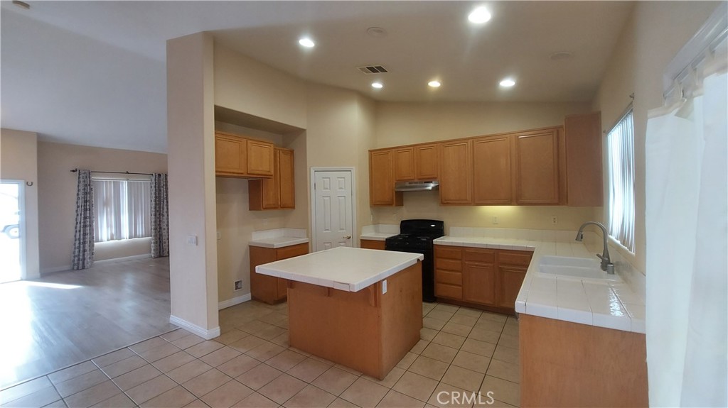 16124 Holly Ridge Court Victorville, CA 92395 - Photo 8 of 24 a large room with a large window and wooden floor