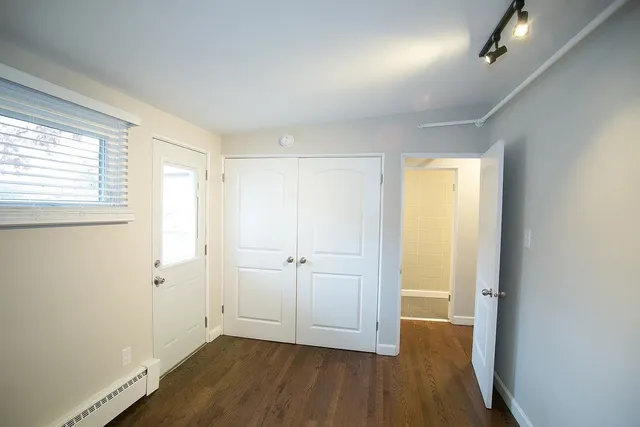 an empty room with wooden floor and windows
