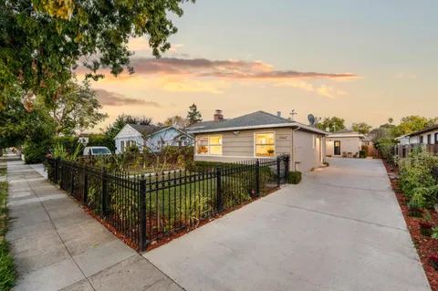 a view of a house with a small yard and wooden fence
