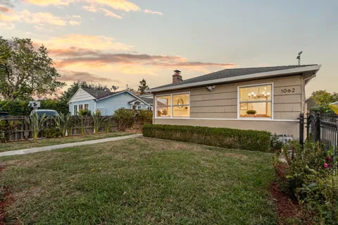 a front view of house with yard and trees around