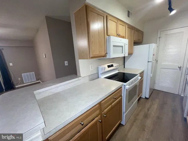a kitchen with a sink a refrigerator and cabinets