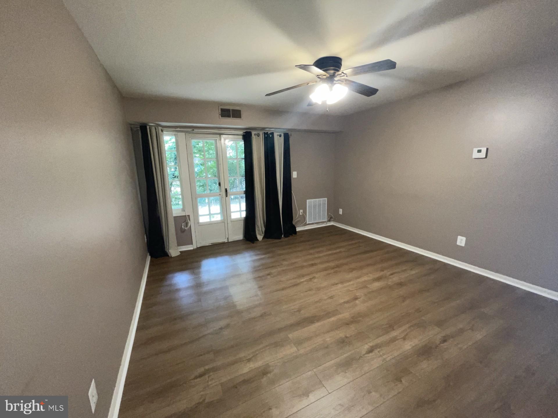 5904 L Bayshire Road, Unit L Springfield, VA 22152 - Photo 5 of 40 an empty room with wooden floor and windows
