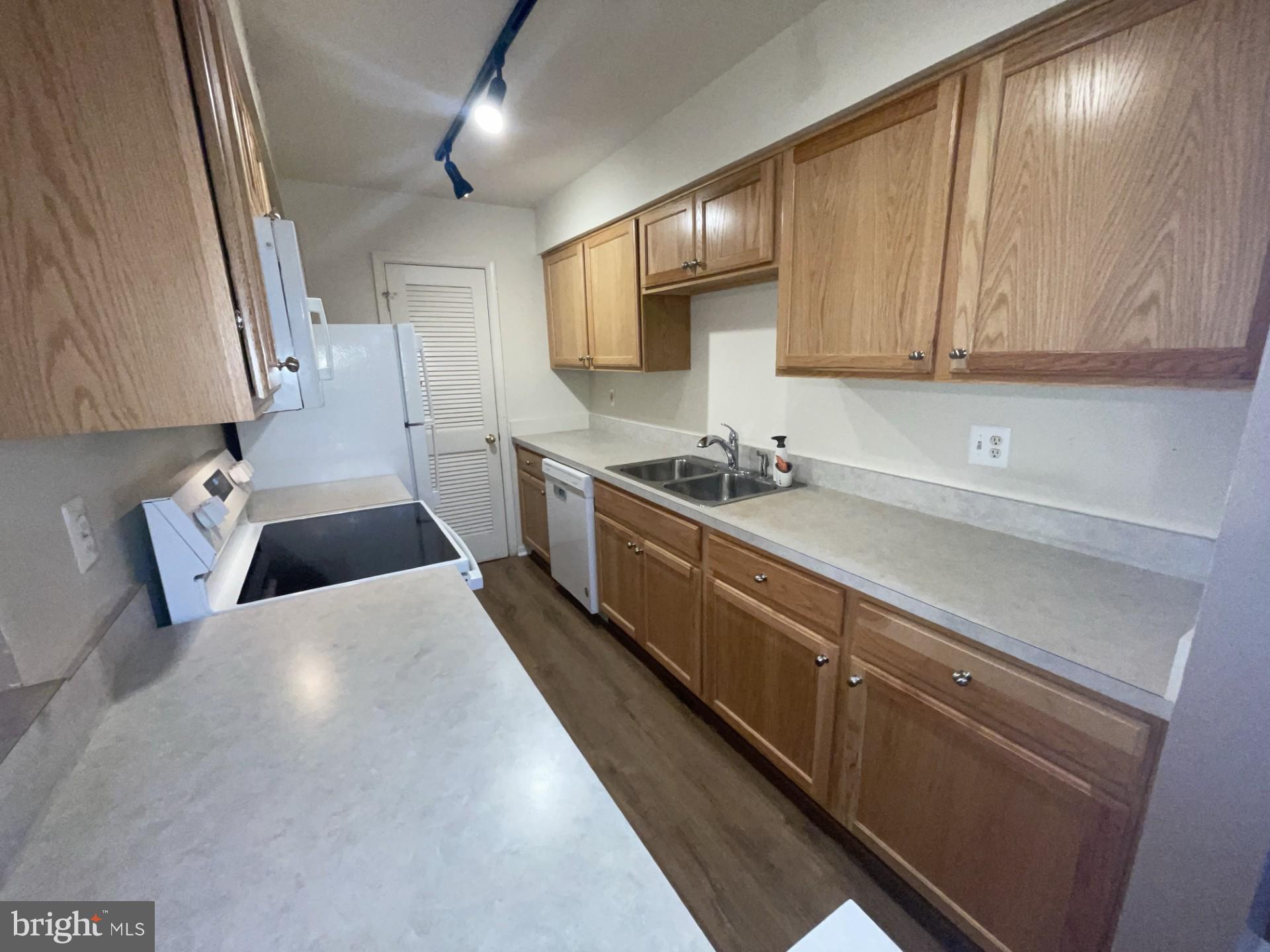 5904 L Bayshire Road, Unit L Springfield, VA 22152 - Photo 9 of 40 a kitchen with stainless steel appliances a sink a stove and cabinets