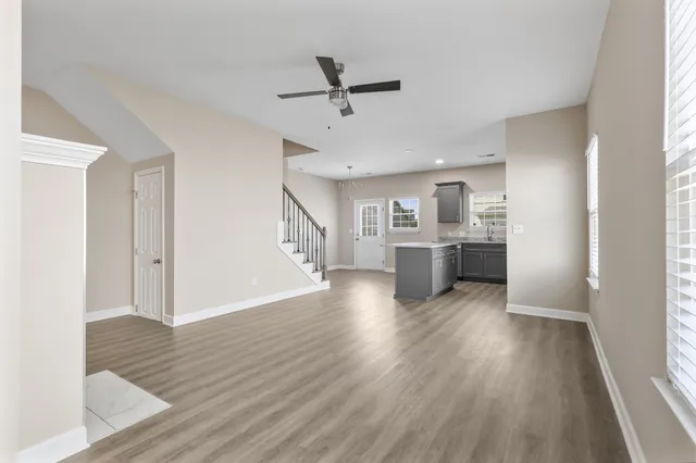 a view of a kitchen with wooden floor and a ceiling fan