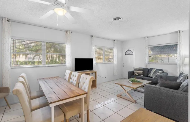 a living room with furniture a flat screen tv and a large window