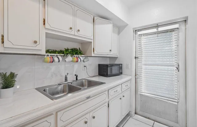 a kitchen with stainless steel appliances white cabinets and a sink