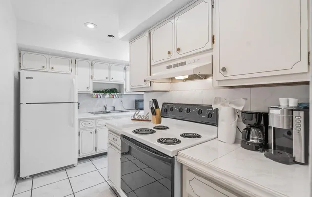a kitchen with refrigerator cabinets and a stove top oven